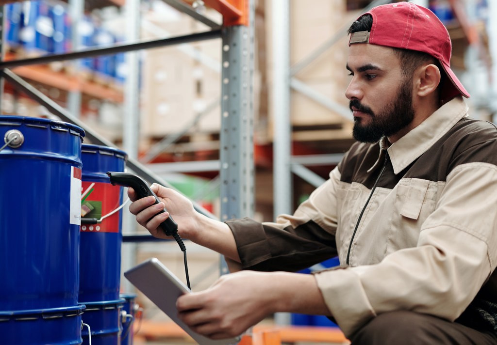 Logistics company employee preparing to safely load a flatbed trailer by inspecting the cargo they will transport on a truck